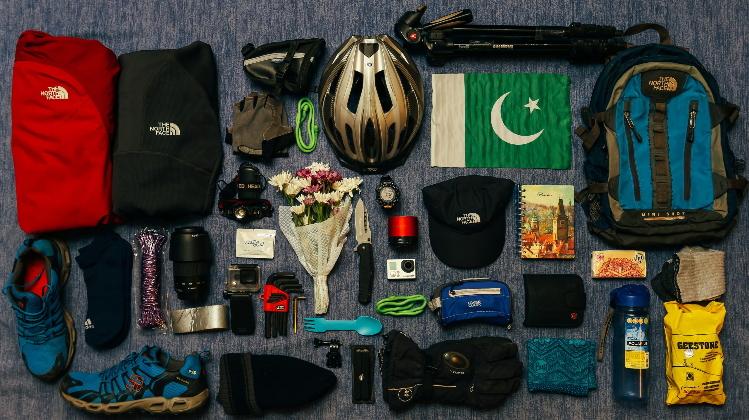 Flat lay photo featuring an open colorful suitcase filled with neatly arranged travel essentials