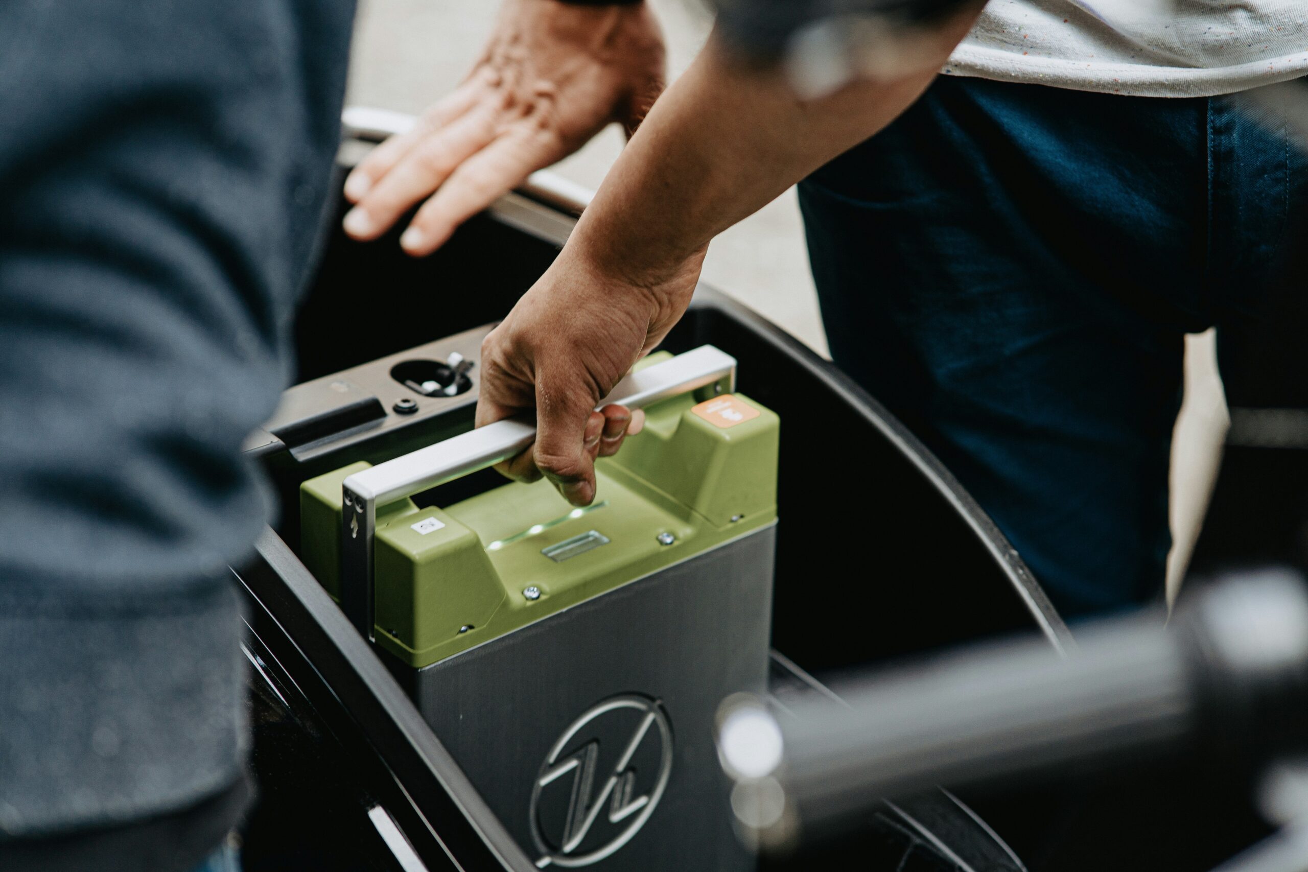 A sleek black portable power bank resting on a stylish suitcase