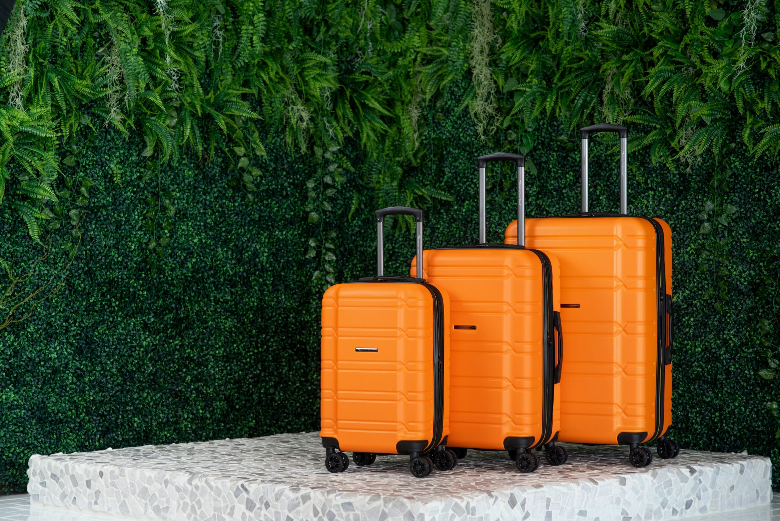 A lineup of plain black luggage at baggage claim.