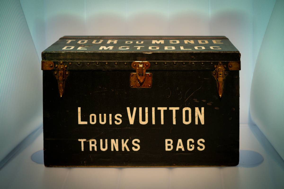 A sleek silver aluminum Rimowa suitcase next to a chic black leather tote