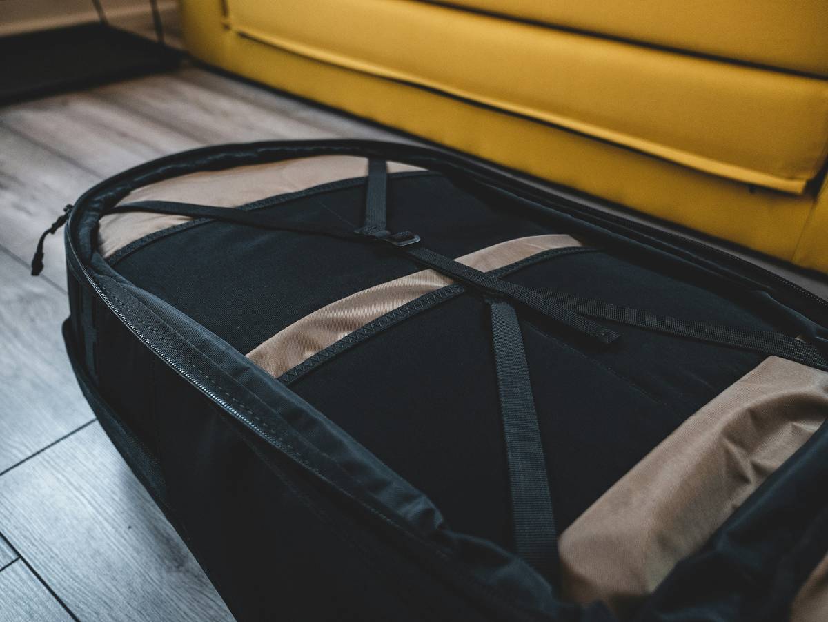 A vlogger setting up her camera equipment next to her stylish yet functional rolling suitcase.