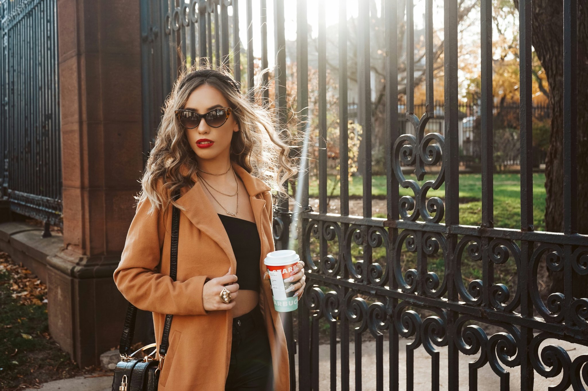 An influencer holding a designer backpack illuminated by soft, golden-hour-inspired studio lighting.