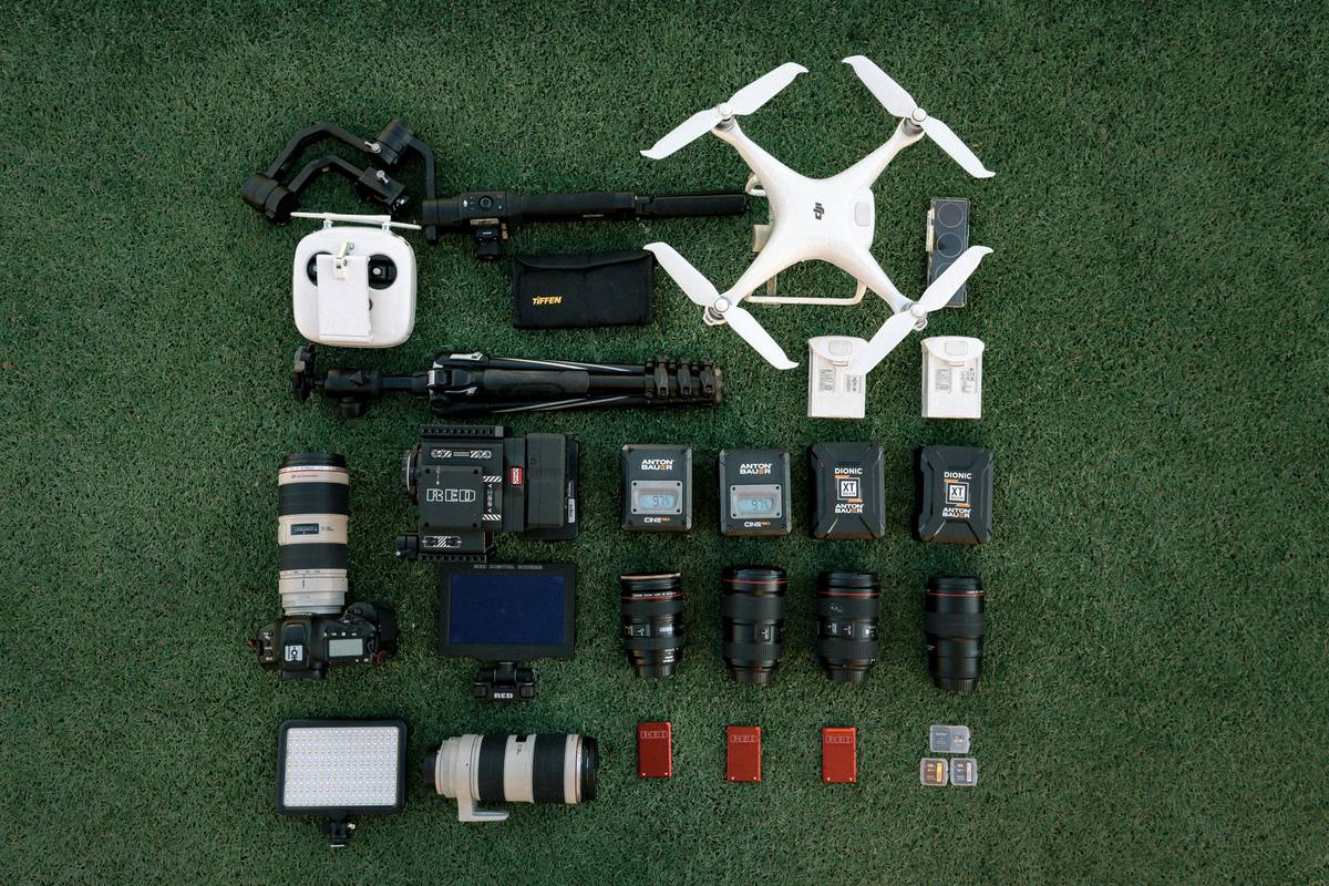 Influencer holding open camera drone travel backpack with gear neatly organized
