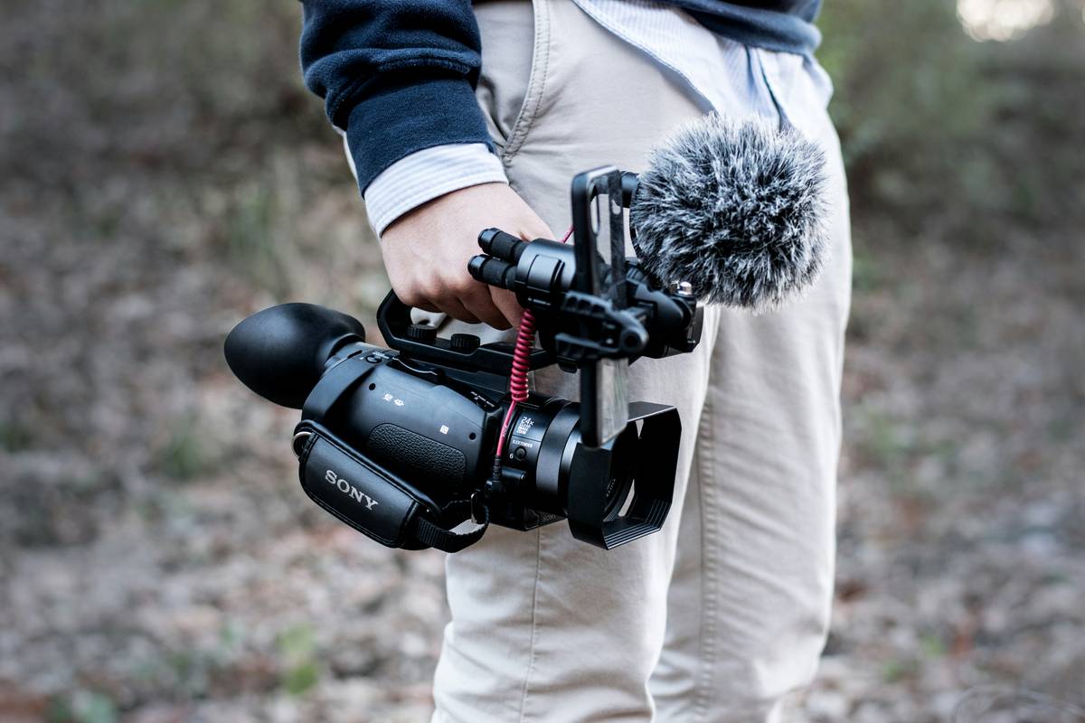 Travel influencer posing with a tripod and its carrying case