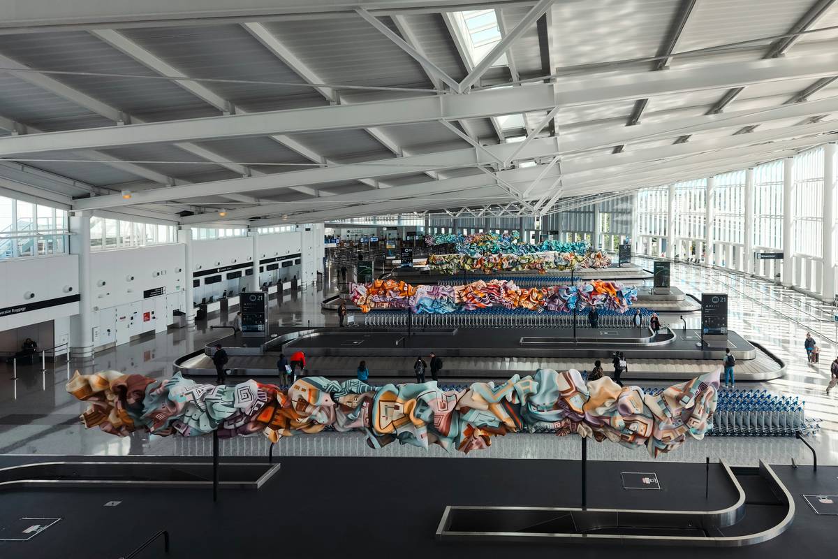 A row of identical black suitcases at baggage claim