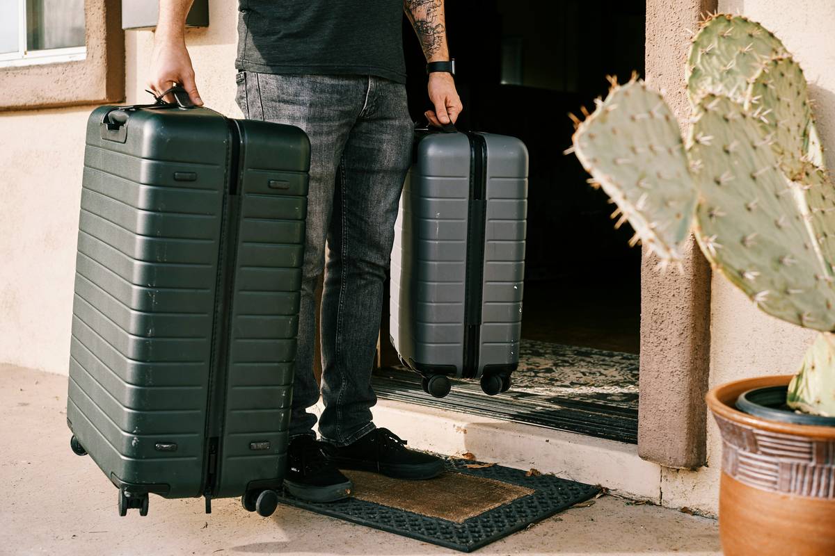 An influencer posing confidently next to her geometric-patterned carry-on