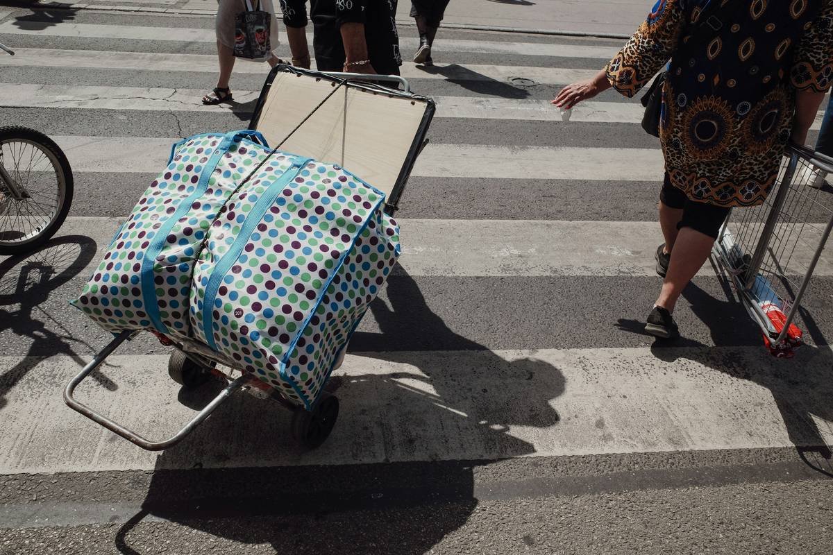 An influencer posing confidently next to her rolling case filled with professional photography equipment