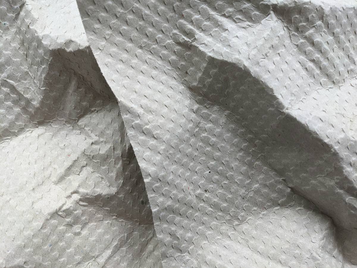 Influencer sitting beside a marble suitcase, smiling confidently at the camera