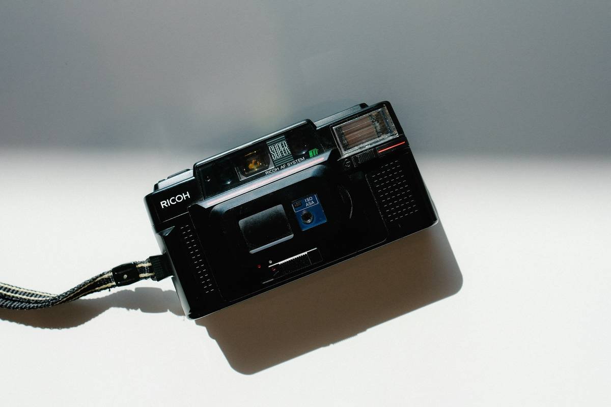 Man holding smartphone showing low battery warning while trying to film a vlog outdoors.