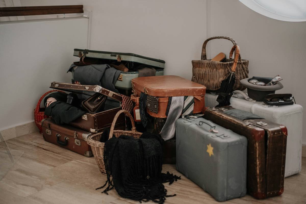 A beautifully styled vintage leather suitcase surrounded by travel accessories like sunglasses, maps, and coffee cups.